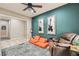 Inviting bonus room with modern lighting, bold accent wall, and cozy seating arrangement at 7497 Alamo Ranch Ave, Las Vegas, NV 89179