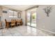 Cozy dining area with a wooden table, tile flooring, and sliding glass doors to the backyard at 7497 Alamo Ranch Ave, Las Vegas, NV 89179