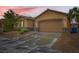 Inviting single-story home boasts an attached two-car garage, stone accents, and well-maintained front yard at 7497 Alamo Ranch Ave, Las Vegas, NV 89179