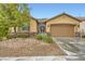 Charming single-story home boasts a 2-car garage, stone accents, and well-maintained desert front yard at 7497 Alamo Ranch Ave, Las Vegas, NV 89179
