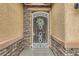 Charming front entrance with decorative wrought iron gate, stone accents, and textured stucco walls at 7497 Alamo Ranch Ave, Las Vegas, NV 89179
