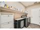 Modern laundry room features a sink, washer, dryer and plenty of storage space at 7497 Alamo Ranch Ave, Las Vegas, NV 89179