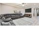 Spacious living room featuring a large sectional sofa, tile floors, and neutral decor with large tv at 7497 Alamo Ranch Ave, Las Vegas, NV 89179