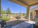 Covered patio with desert landscaping overlooking a green space and the blue sky in a tranquil outdoor setting at 7624 Fruit Dove St, North Las Vegas, NV 89084