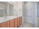 Bathroom featuring a dual sink vanity, neutral tones, and a shower with glass door at 7624 Fruit Dove St, North Las Vegas, NV 89084