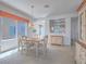 Bright dining room with a light wood table, four upholstered chairs, and view to kitchen at 7624 Fruit Dove St, North Las Vegas, NV 89084