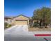 Single Gathering home with a two car garage, desert landscaping, and front lawn tree at 7624 Fruit Dove St, North Las Vegas, NV 89084