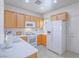 Well-lit kitchen boasts white appliances, oak cabinets, and ample counter space for meal preparation at 7624 Fruit Dove St, North Las Vegas, NV 89084
