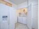 Well-equipped laundry room with modern washer and dryer units, storage shelves, and a utility sink at 7624 Fruit Dove St, North Las Vegas, NV 89084