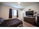Bright bedroom featuring a large window, television, and dark wood floors at 7890 Aurora Sky St # 1, North Las Vegas, NV 89084