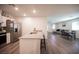 Open concept living room features modern kitchen with stainless appliances, dining area and comfortable seating at 7890 Aurora Sky St # 1, North Las Vegas, NV 89084