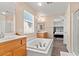 Bright bathroom with soaking tub, dual sinks, walk-in shower and and archway to bedroom at 8059 Wards Ferry St, Las Vegas, NV 89139
