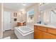 Bright bathroom with white cabinets, large soaking tub, dual sinks and wood-style flooring at 8059 Wards Ferry St, Las Vegas, NV 89139