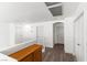 Upstairs hallway with wood flooring and white walls, features three doors and a built in cabinet at 8059 Wards Ferry St, Las Vegas, NV 89139