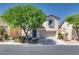 Inviting two-story home featuring a two-car garage, lovely desert landscaping, and charming architectural details at 8824 Charm Canyon Ave, Las Vegas, NV 89178