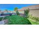 A backyard with green grass, plants, and a small pool at 96 Campbelltown Ave, Henderson, NV 89015