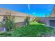View of a small backyard with grass and plants, enclosed by a block wall, offering a private outdoor space at 96 Campbelltown Ave, Henderson, NV 89015