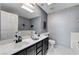 Bathroom features double sinks, a big mirror, white tiled floors, and grey walls at , Las Vegas, NV 89118