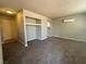 A well-lit living room features neutral tones, built-in shelving, plush carpeting, and air conditioning unit at 100 S Crestline Dr # 18, Las Vegas, NV 89107