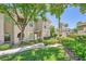 Multi-story residential building with well-maintained landscaping, trees, grass, and sidewalk at 10001 Peace Way # 2335, Las Vegas, NV 89147