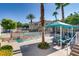 Community pool area with covered seating, palm trees, and a decorative iron fence at 10001 Peace Way # 2335, Las Vegas, NV 89147