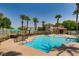 Community pool with palm trees, shallow splash area, and lounging area with sun umbrellas at 10001 Peace Way # 2335, Las Vegas, NV 89147