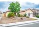 Charming single-story house with a low-maintenance front yard featuring gravel landscaping and mature trees at 1027 Dawn Valley Dr, North Las Vegas, NV 89031