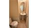 A half bathroom with tile flooring features a pedestal sink and an oval mirror at 1030 Maple Pines Ave, North Las Vegas, NV 89081
