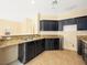 The kitchen features dark cabinetry, stone countertops, stainless steel sink, and tile flooring at 1030 Maple Pines Ave, North Las Vegas, NV 89081