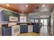 Well-equipped kitchen features blue cabinetry, a gas range, and views into the adjacent living space at 10456 Processor Ct, Las Vegas, NV 89129