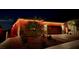 Inviting single-story home beautifully illuminated with accent lighting, showcasing its charming facade and landscaping at 10943 Artisan Ranch Ave, Las Vegas, NV 89166