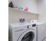 Bright laundry room with LG washer and dryer, and shelving above at 10943 Artisan Ranch Ave, Las Vegas, NV 89166