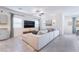 Inviting living room features a large sectional sofa, mounted TV, and tile floors with neutral tones at 10943 Artisan Ranch Ave, Las Vegas, NV 89166
