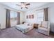 Bright main bedroom with platform bed, ceiling fan, and cozy accent chair at 10943 Artisan Ranch Ave, Las Vegas, NV 89166