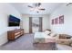 Well-lit main bedroom with a large dresser, ceiling fan and comfortable seating at 10943 Artisan Ranch Ave, Las Vegas, NV 89166