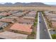 An aerial perspective showcases a neighborhood street with well-maintained homes and desert landscaping at 10943 Artisan Ranch Ave, Las Vegas, NV 89166