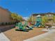 Playground featuring slides, climbing structures, and benches, set on a mulch ground with surrounding landscaping at 10943 Artisan Ranch Ave, Las Vegas, NV 89166