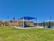 Community playground featuring a slide and other play equipment set on a grassy lawn under a bright blue sky at 10943 Artisan Ranch Ave, Las Vegas, NV 89166