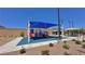 Bright playground featuring a covered play structure, picnic benches, and a restroom in a new community at 10943 Artisan Ranch Ave, Las Vegas, NV 89166