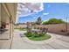 This back yard offers a covered patio, a large dining table, and professional landscaping at 1117 Azure Heights Pl, Las Vegas, NV 89110