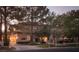 Elegant two-story home with manicured lawn and mature trees at twilight at 1413 Iron Hills Ln, Las Vegas, NV 89134