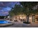Stunning outdoor pool with stone surround, landscaped patio, and covered seating area at 1413 Iron Hills Ln, Las Vegas, NV 89134