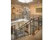 Elegant staircase with ornate wrought iron railing and chandelier adds architectural charm to this home at 1413 Iron Hills Ln, Las Vegas, NV 89134