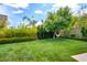 Serene backyard oasis with a hammock hanging from a tree, mature landscaping, and green grass at 1701 Tesara Vista Pl, Las Vegas, NV 89128