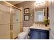 Charming bathroom with a glass shower, patterned wallpaper, and a vanity with marble countertop at 1701 Tesara Vista Pl, Las Vegas, NV 89128