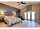 Bedroom with a ceiling fan, carpeted floor, large windows and grey accent wall at 1701 Tesara Vista Pl, Las Vegas, NV 89128