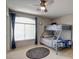 Cozy bedroom featuring a bunk bed, large window with curtains, and carpeted floors at 1701 Tesara Vista Pl, Las Vegas, NV 89128