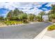 Community entrance with lush landscaping and a welcoming sign at 1701 Tesara Vista Pl, Las Vegas, NV 89128