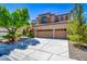 Stunning two-story home with a three-car garage and meticulously landscaped front yard at 1701 Tesara Vista Pl, Las Vegas, NV 89128