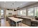 Bright kitchen boasts a center island with seating, tile backsplash, and stainless steel appliances at 1701 Tesara Vista Pl, Las Vegas, NV 89128